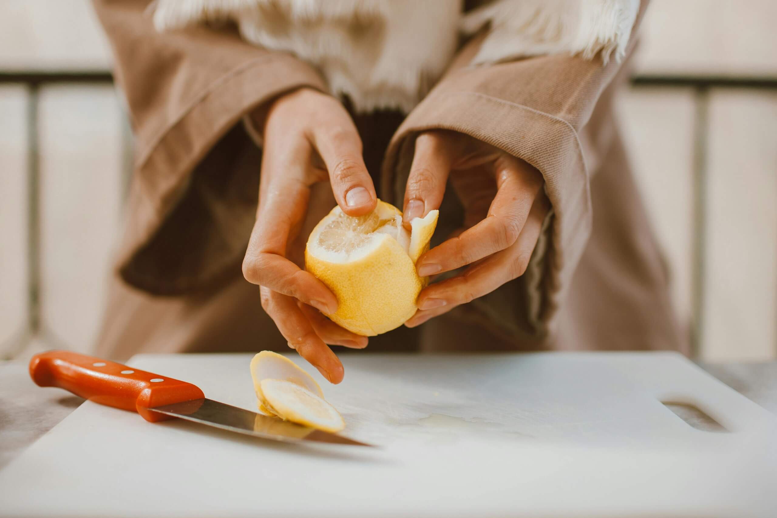Woman peeling a lemon