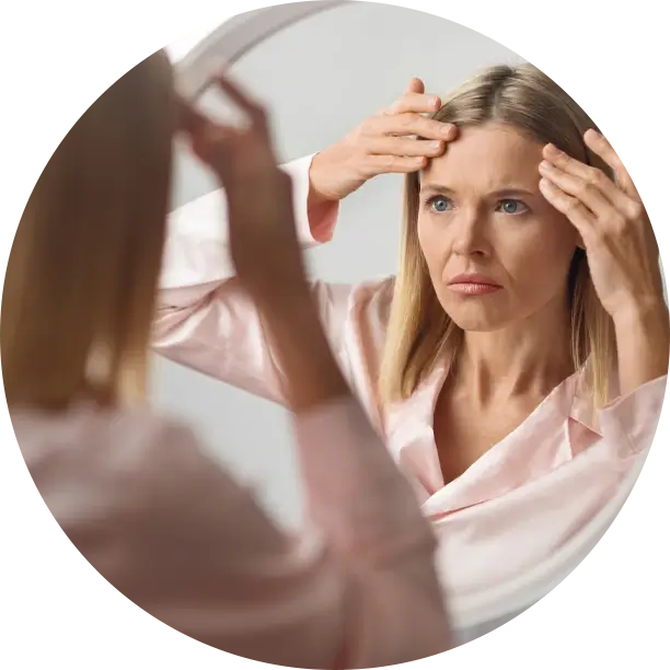 woman looking at forehead in mirror